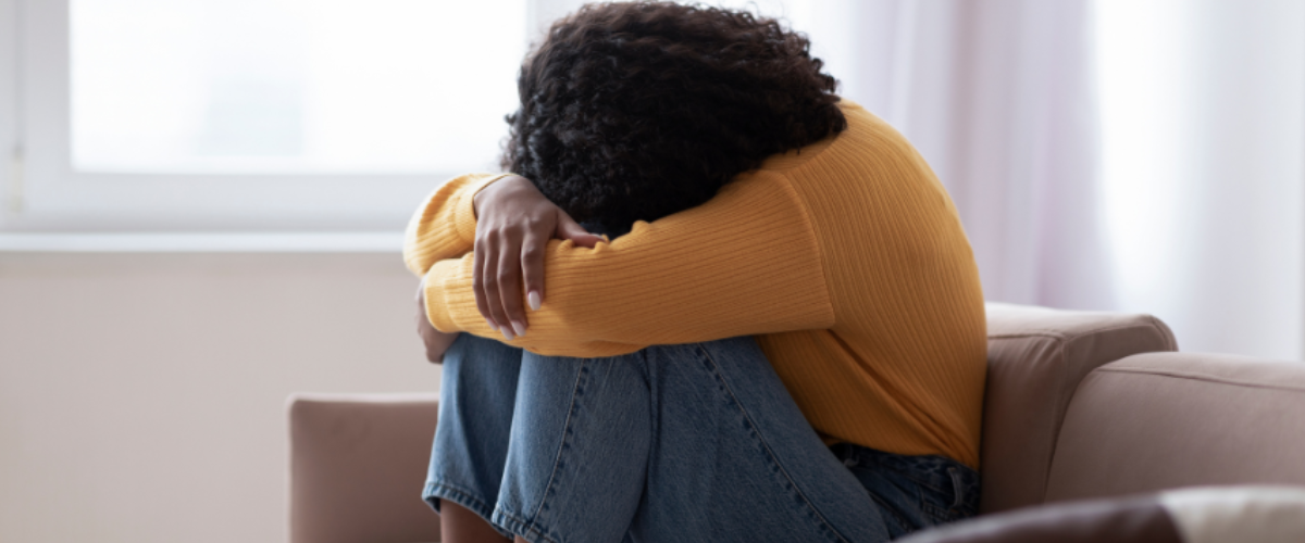 A woman resting on a sofa, finding a quiet moment of support