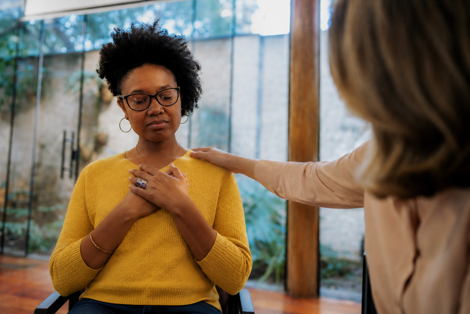 A young woman talking with a supportive listener over a cup of tea